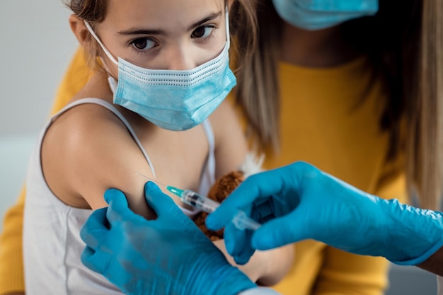 Small girl receiving a vaccine due to coronavirus pandemic