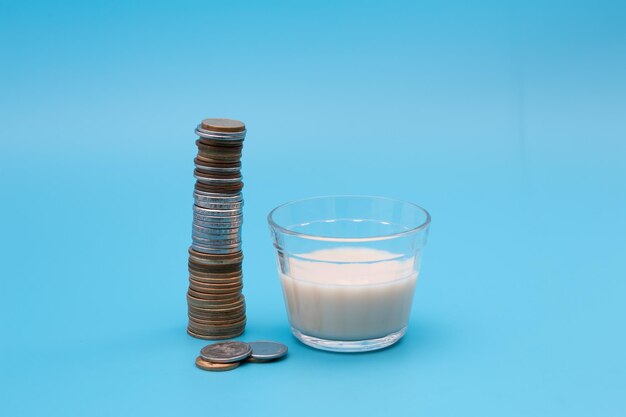 Small glass of milk with coins around