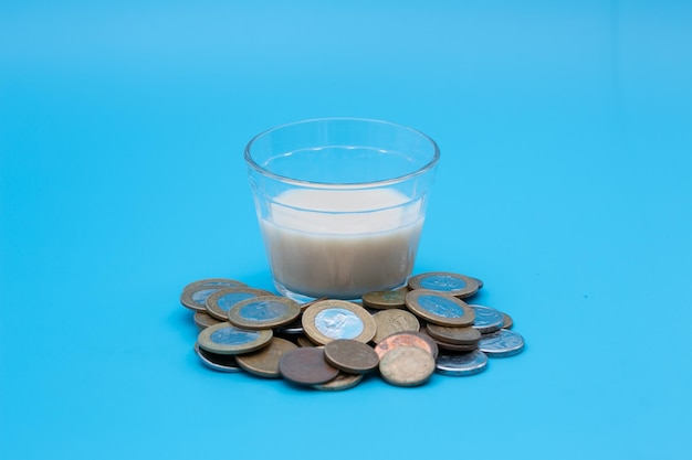 Small glass of milk with coins around