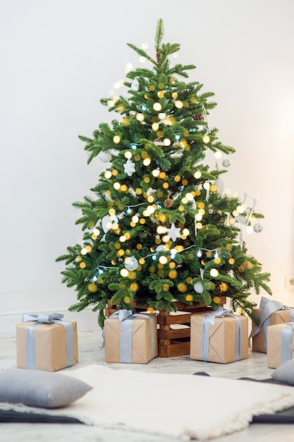 Small green Christmas tree with lights and gifts