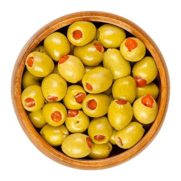 Small green olives filled with sweet peppers in wooden bowl