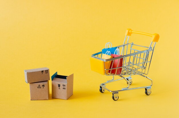 A small grocery cart with boxes and bags on yellow