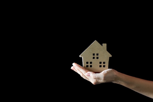 Small home model in woman hand. - buy house and real estate concept.