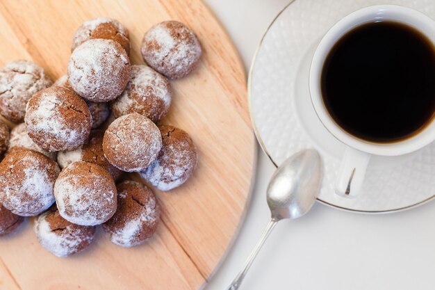 Photo small homemade chocolate chip cookies with powdered sugar and espresso in a white cup