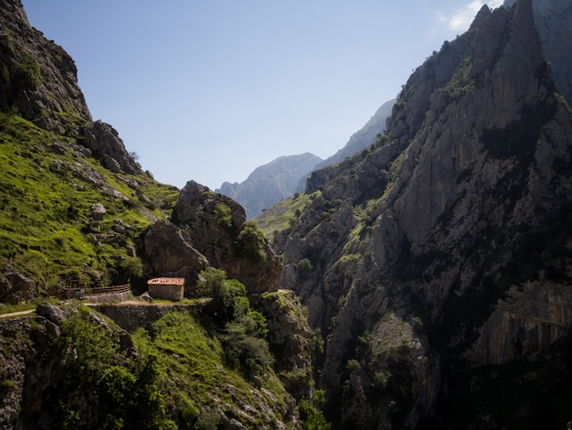 Small house on the edge of the precipice in huge mountains