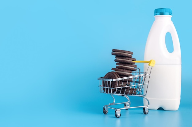 Small metal supermarket trolley full of fresh sweet of chocolate cookies with bootle milk