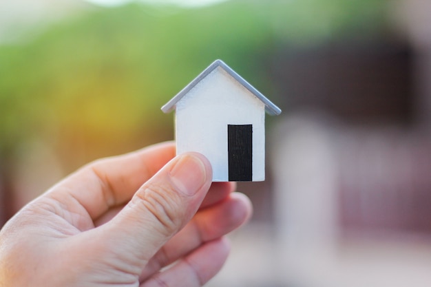 Small model house on the hands of men