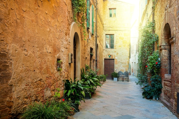 Small Old Mediterranean town lovely Tuscan street in Pienza with sunshine and flowers Italy