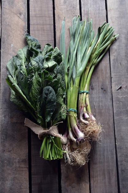 Small onions and spinach on a table rustic