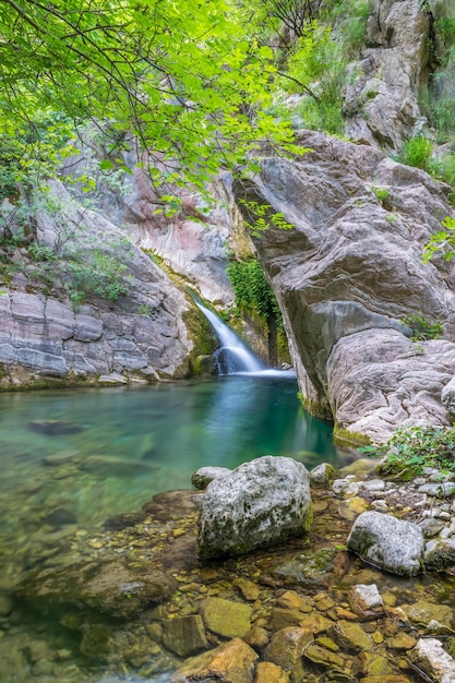 A small picturesque waterfall in a cozy mountain lagoon