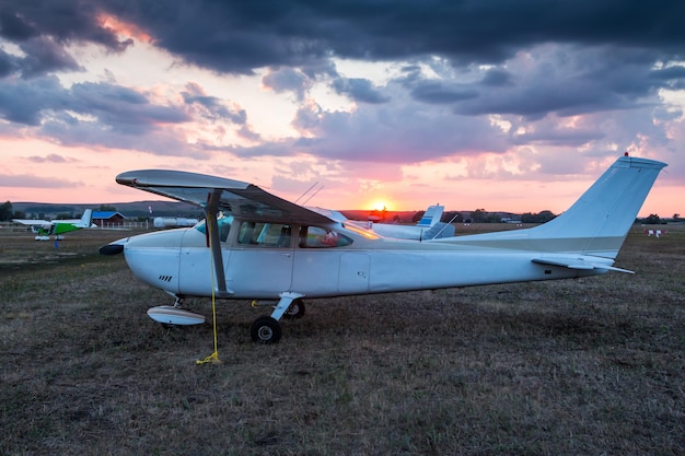 Small private aircrafts parked at the airfield at picturesque sunset