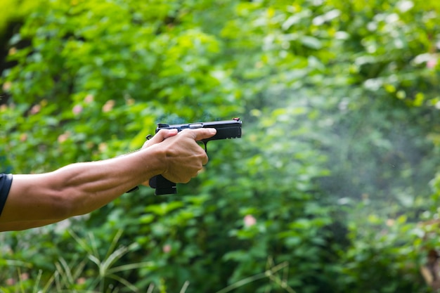 Small puff of smoke coming from a handgun after being fired