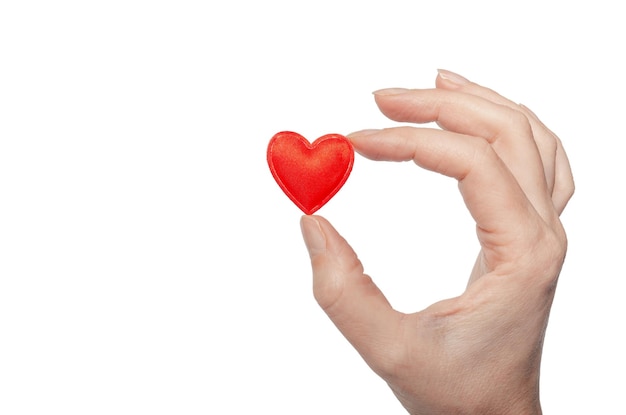 Small red heart in female fingers Holiday symbol