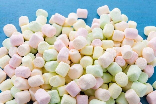 Small round multicolor marshmallows on blue backgrouns.