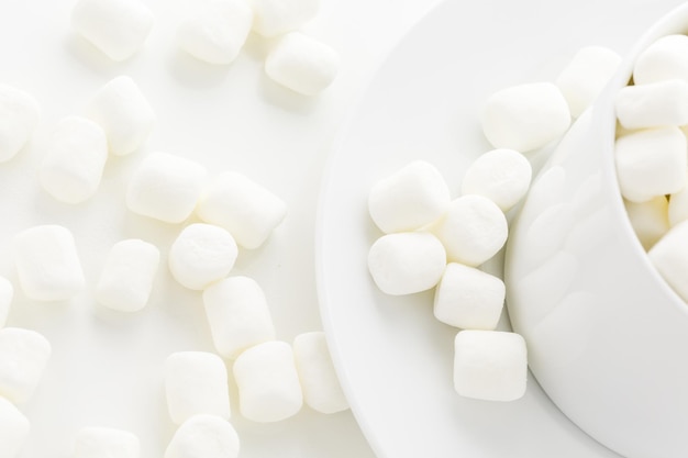 Small round white marshmallows on a white backgrouns.