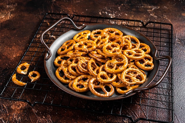 Small salted pretzels crackers with salt Dark background Top view