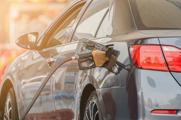 Small silver car refuelling at the gas station