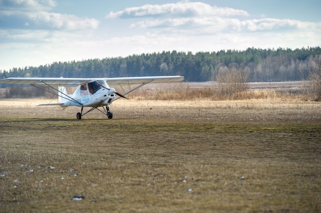 A small single-engine plane makes a landing on the ground.