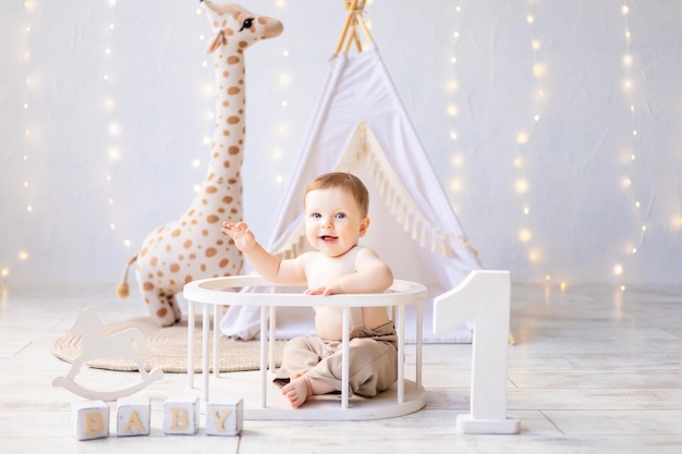 A small smiling baby boy playing in the nursery a bright cozy children's room the first birthday of the baby the first year props for the holiday