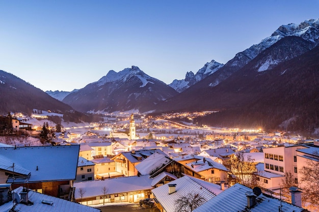 small snowy houses in a town with amazing sky and mountains