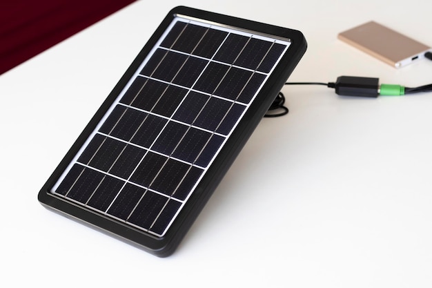 A small solar panel on a white background charges a paverbank