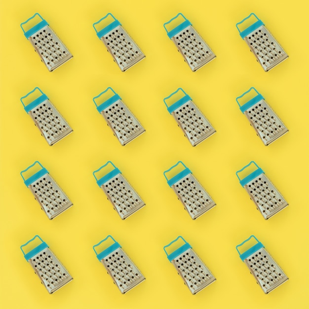 Small stainless steel graters lies on yellow