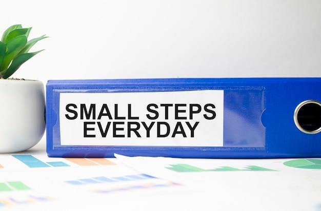 Small steps everyday text written on blue folder and charts