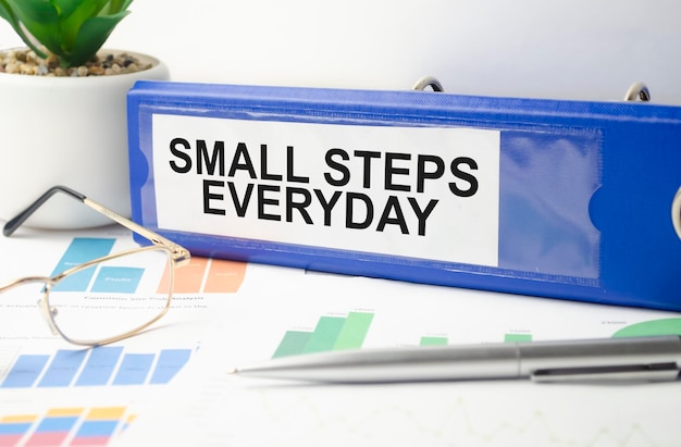 Small steps everyday text written on blue folder and charts