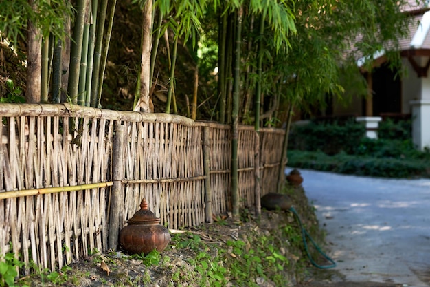 A small street of a Thai village Bamboo fence and blurred house in the background Calm atmosphere for rest