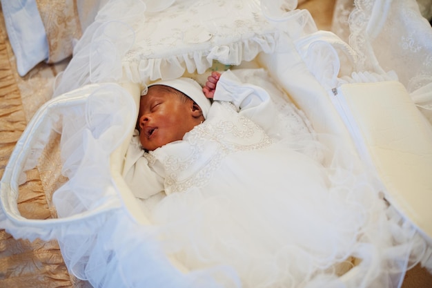 Small tiny newborn african american baby laying on the bed