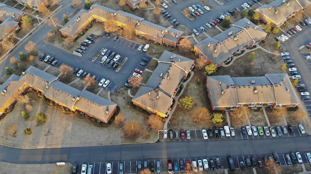 Small town rooftops neighborhood with trees homes in aerial drone view on autumn late time