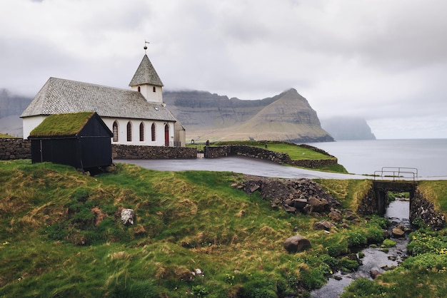 Small village church on the sea shore in Vidareidi Faroe Islands Denmark