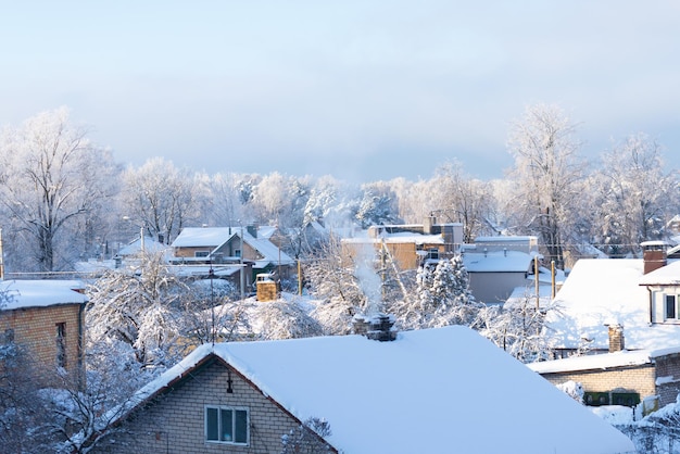 Small village in winter day, roofs with deep snow