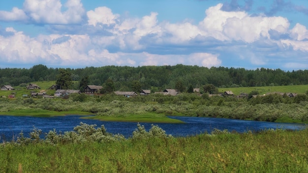 Small village with old wooden houses on the banks of the river in summer in the Arkhangelsk region