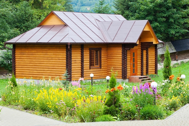 Small village wooden house with flower bed