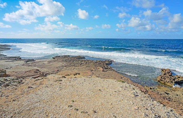 Small waves and brown rocks in Argentiera Sardinia