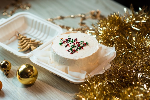 Small white bento cake with christmas tree decor in the table Christmas mood photo for confectioner content