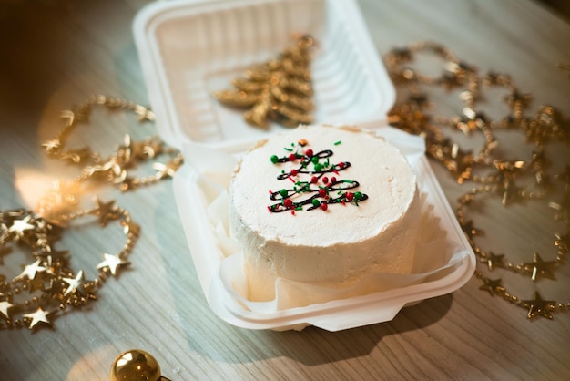 Small white bento cake with christmas tree decor in the table Christmas mood photo for confectioner content