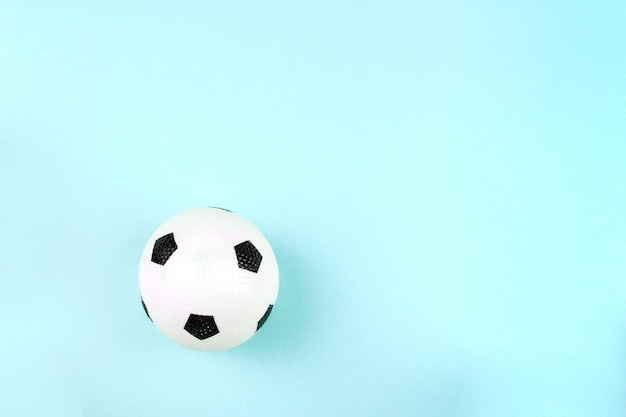 Photo small white black ball for football sport game on blue background.