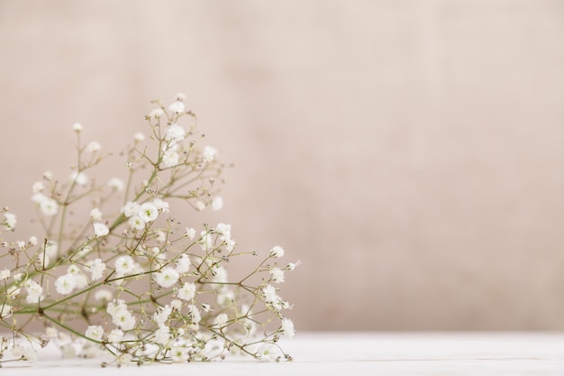 Small white flowers gypsophila on wood table. Minimal lifestyle concept. Copy space