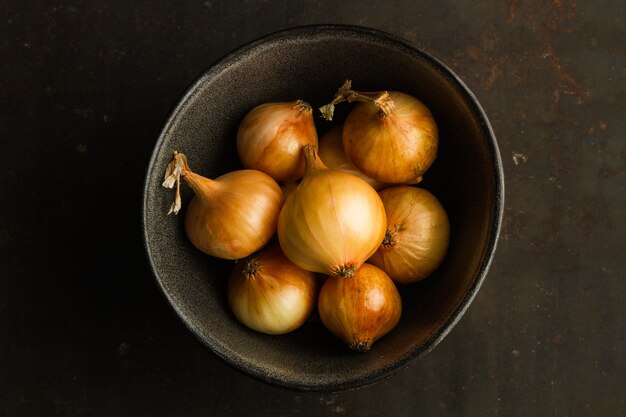 Small white french onions in a dark bowl