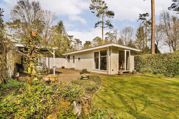 A small white house with a yard and a garden