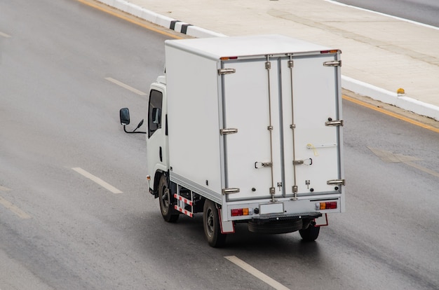 Small white truck running on the road.