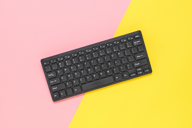 A small wireless keyboard on a red and yellow background Peripheral devices for computers