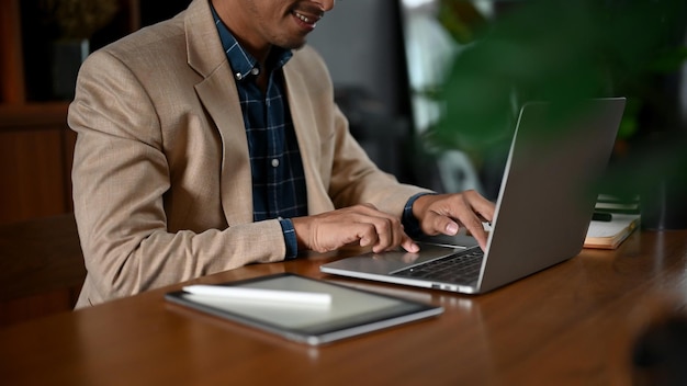 Smart adult Asian businessman using his laptop computer at her desk