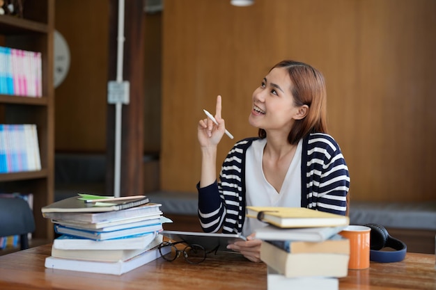 Smart asian young student having idea startup while reading a book