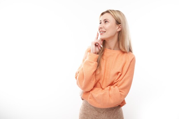 Smart blonde girl in casual holding chin thinks doubts makes decision isolated on white studio background