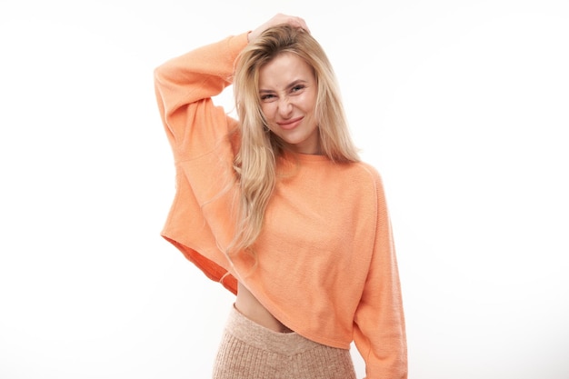 Smart blonde girl in casual holding her head thinks doubts makes decision isolated on white studio background