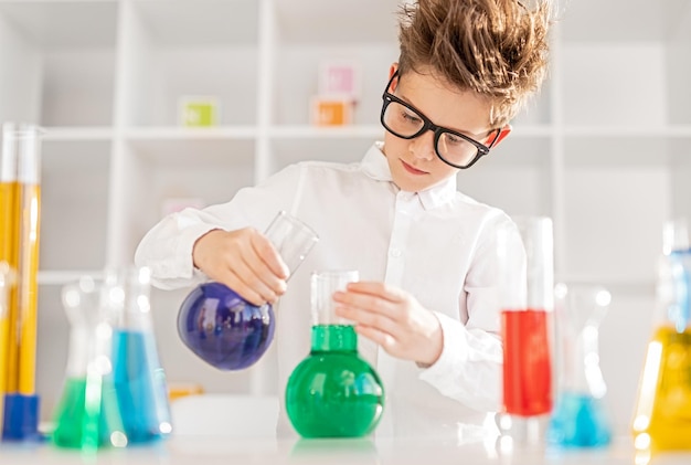 Smart boy conducting experiment with liquids