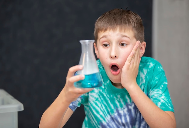 Smart boy scientist screaming in surprise while doing chemical experiments in the laboratory